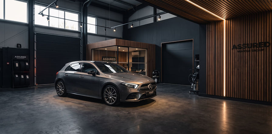 Illustration of our showroom vision: a car under warm light beside timber-slatted walls